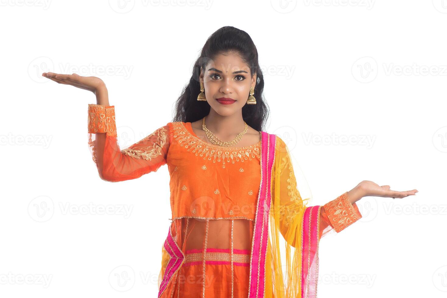 Portrait of cheerful Indian traditional young woman presenting something on hand, showing copy space on her palm on a white background photo