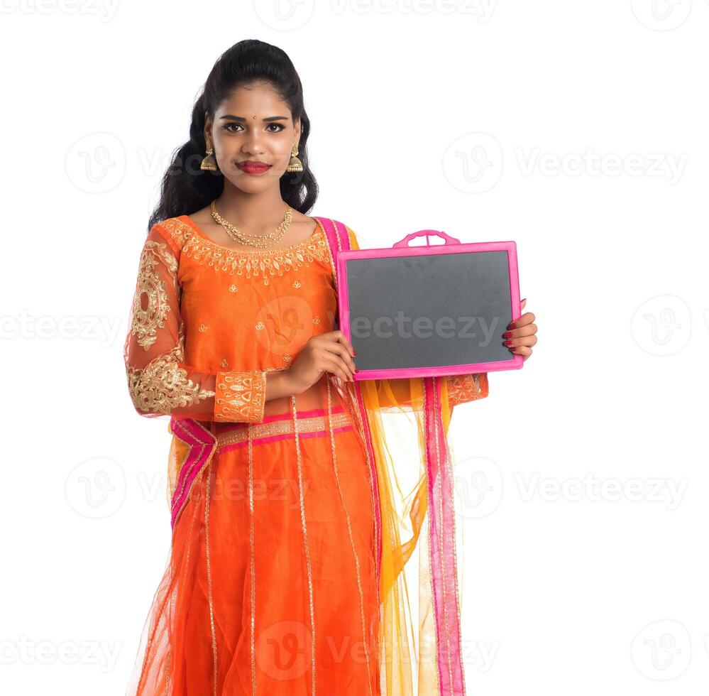 Beautiful young woman holding and posing with a blank chalkboard slate on a white background photo