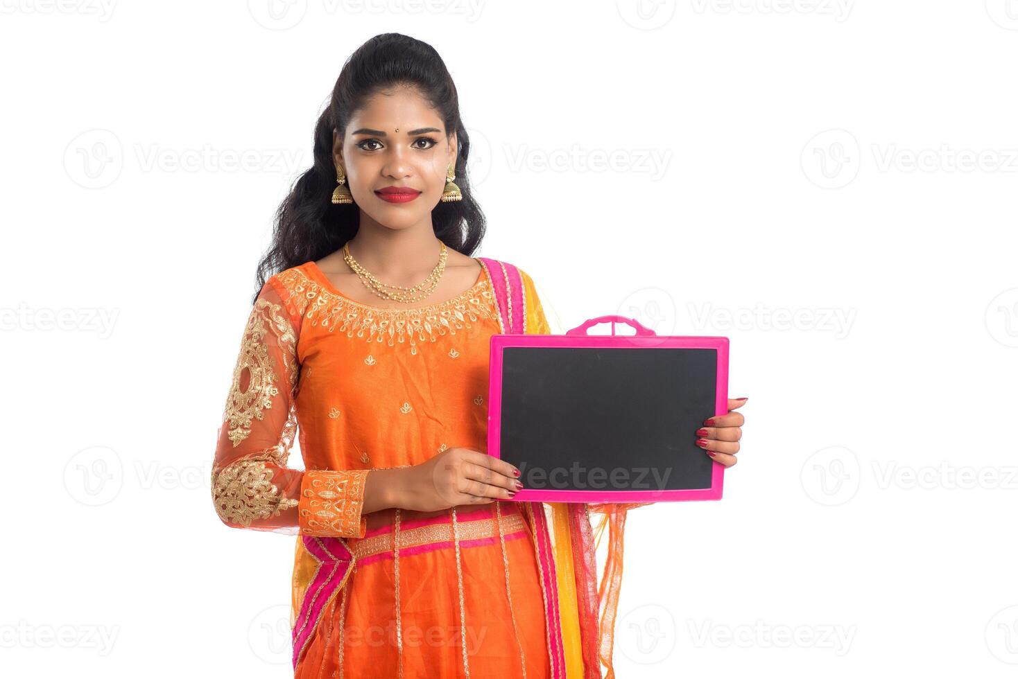 Beautiful young woman holding and posing with a blank chalkboard slate on a white background photo