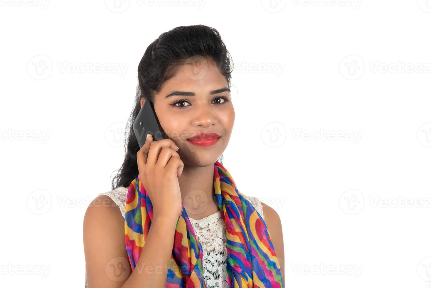 Young Indian girl using a mobile phone or smartphone isolated on a white background photo