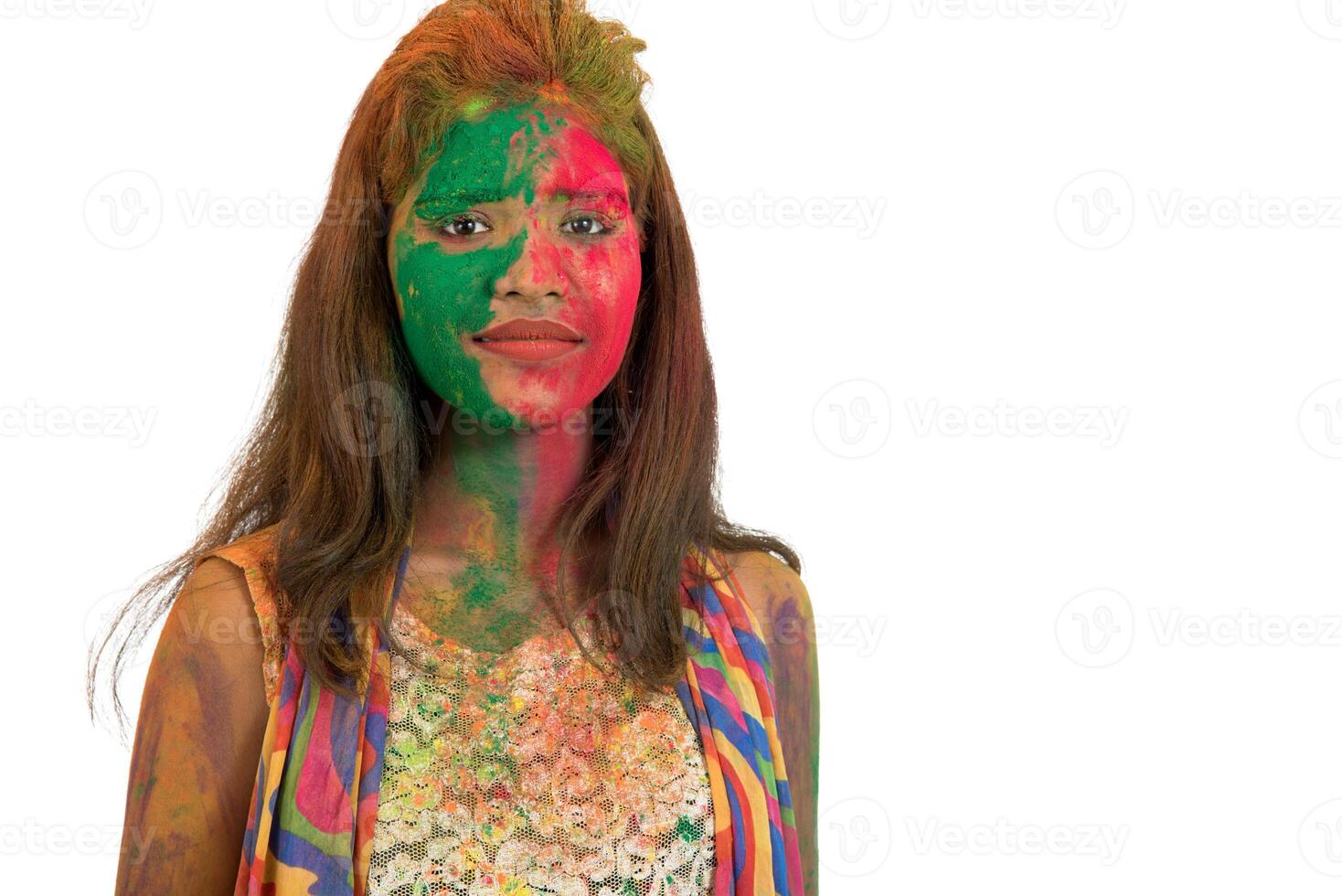 Portrait of a happy young girl with a colorful face on Holi color festival on white background photo