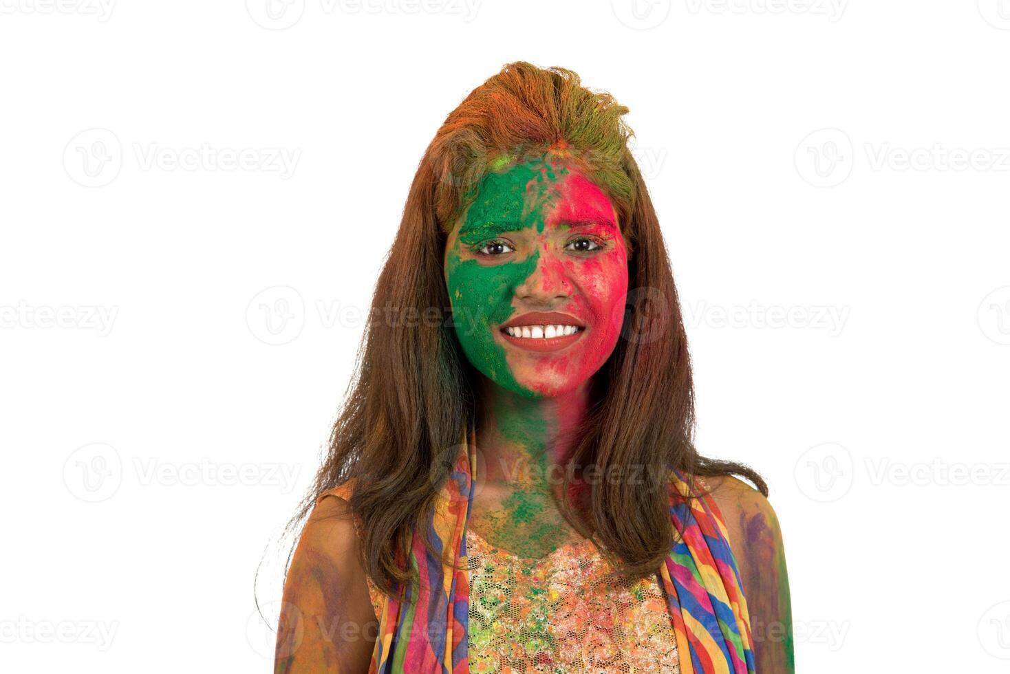 Portrait of a happy young girl with a colorful face on Holi color festival on white background photo
