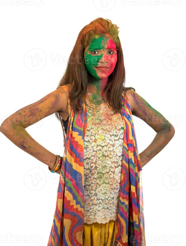 Portrait of a happy young girl with a colorful face on Holi color festival on white background photo