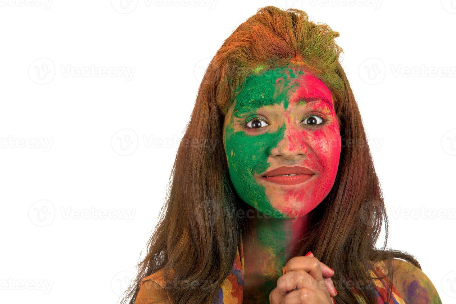 Portrait of a happy young girl with a colorful face on Holi color festival on white background photo