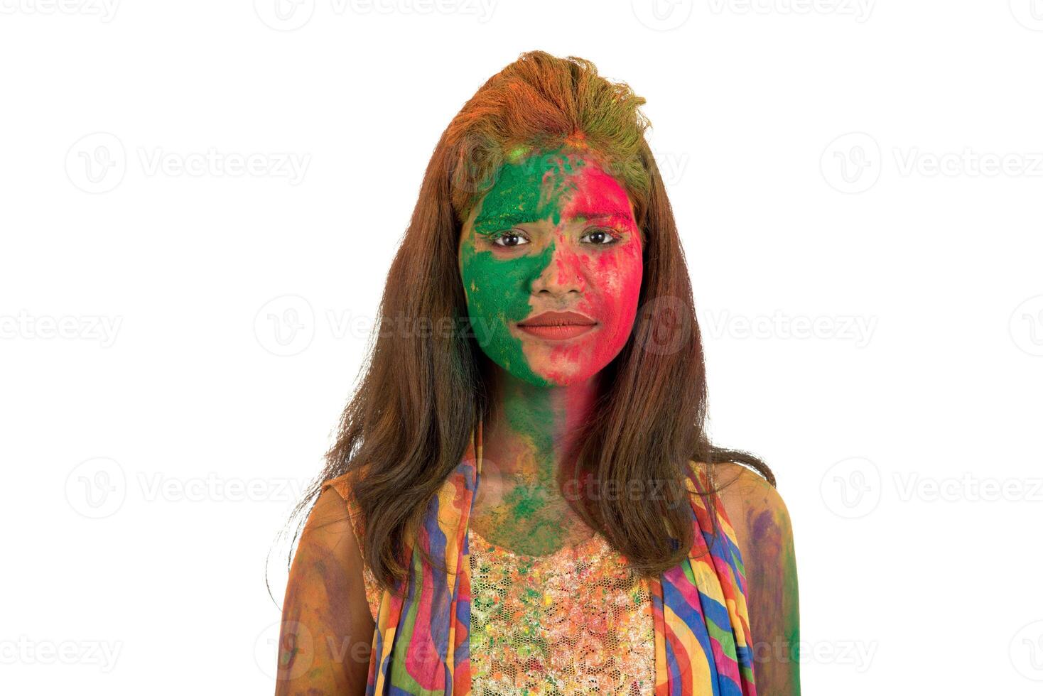 Portrait of a happy young girl with a colorful face on Holi color festival on white background photo