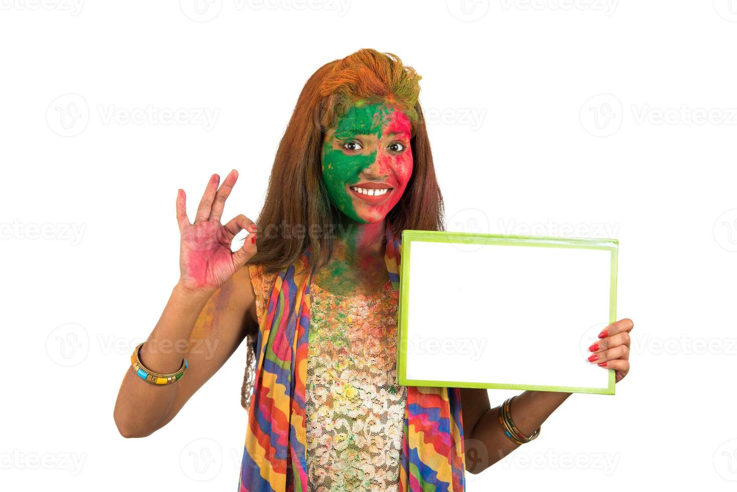 Girl holding a white signboard with face painted with color in Festival of Colour Holi. Isolated portrait photo