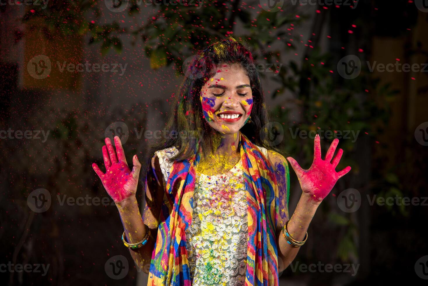 Young girl showing colorful palm and celebrating Holi with color splash photo