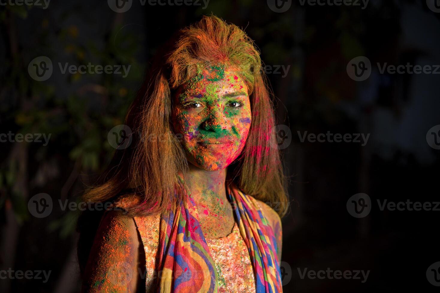 A young girl plays with colors. The concept for Indian festival Holi. color splash. photo