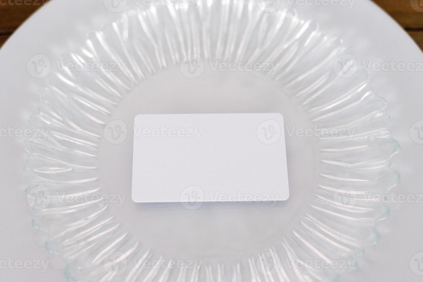 White blank mock-up of a guest card on a glass plate. Serving a festive banquet wedding or birthday party photo