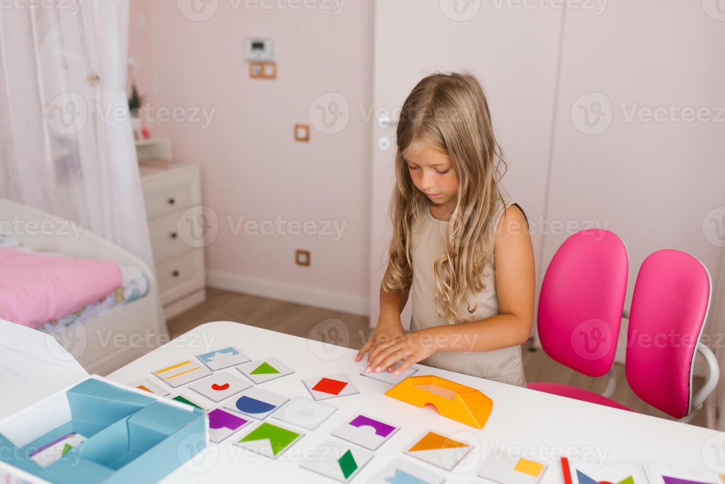 Lifestyle of a smart girl playing a logic game at home. The concept of board games for children, a candid series with real people in a modern interior photo