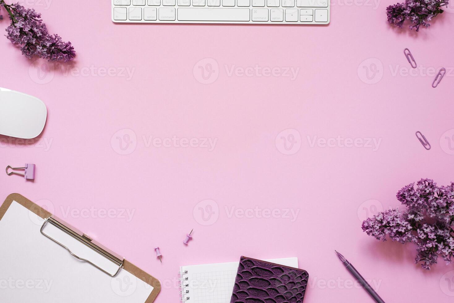Keyboard and mouse, office supplies, a bouquet of lilacs on a pink background. Purple spring flowers. Composition for a blogger. Copy space photo