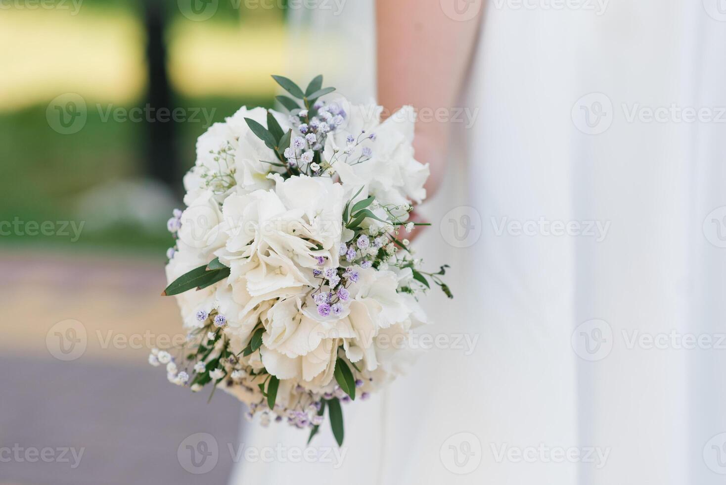 Wedding bouquet with white hydrangea in the hands of the bride photo