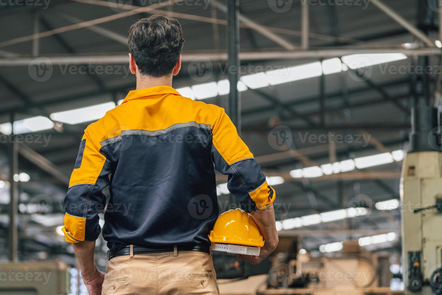 Caucasian engineer using a laptop in a factory. man working in plastics factory. photo
