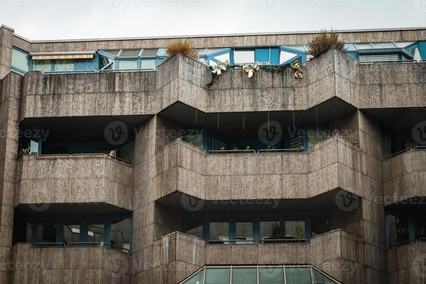 A concrete apartment building with balconies and windows in an urban setting photo