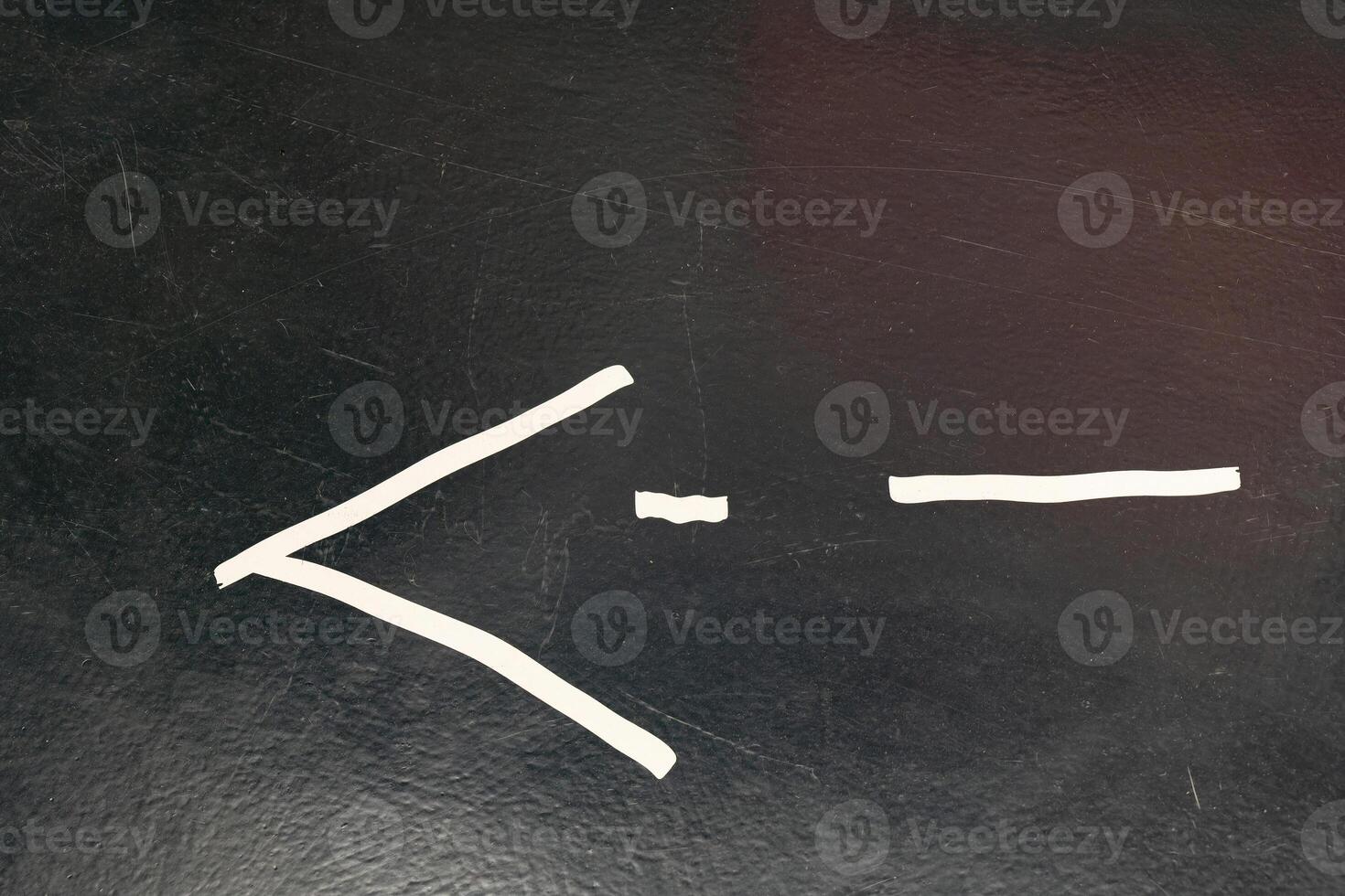 A simple drawing of the less than or equal to sign on a black board photo
