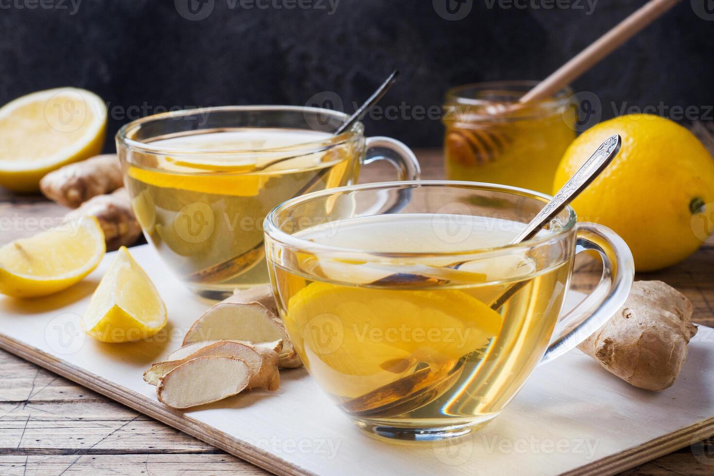 Two cups of natural herbal tea ginger lemon and honey on a wooden background. photo