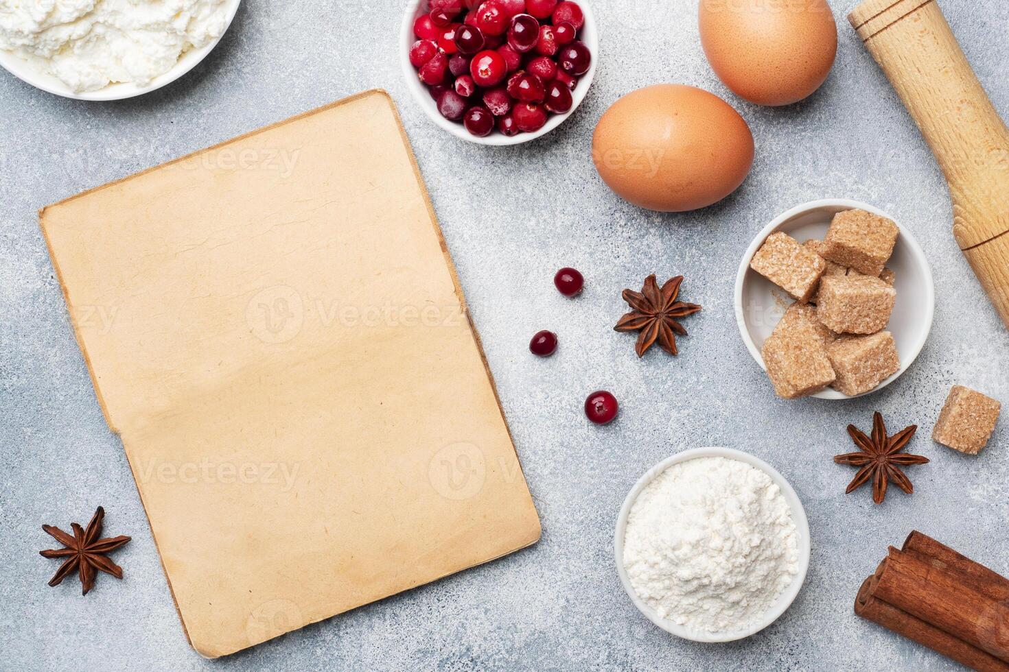 Ingredients for baking cookies, cupcakes and cake. Raw foods eggs flour sugar cottage cheese cranberries on a grey background with copy space. photo