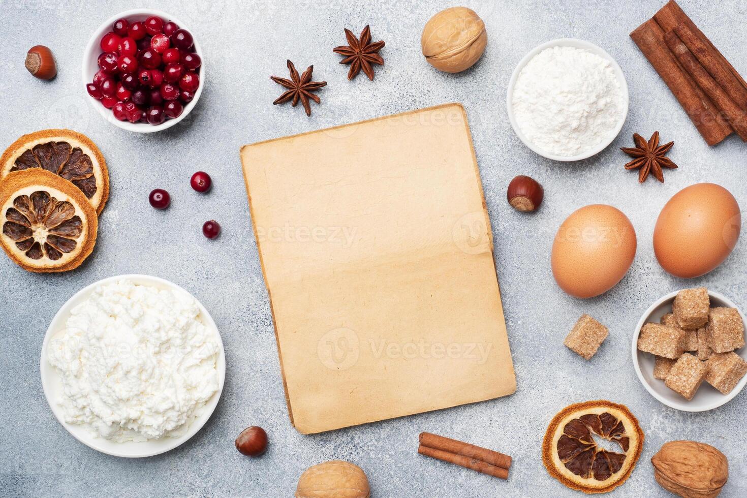 Ingredients for baking cookies, cupcakes and cake. Frame of Raw foods eggs flour sugar cottage cheese cranberries on a grey background with copy space. photo