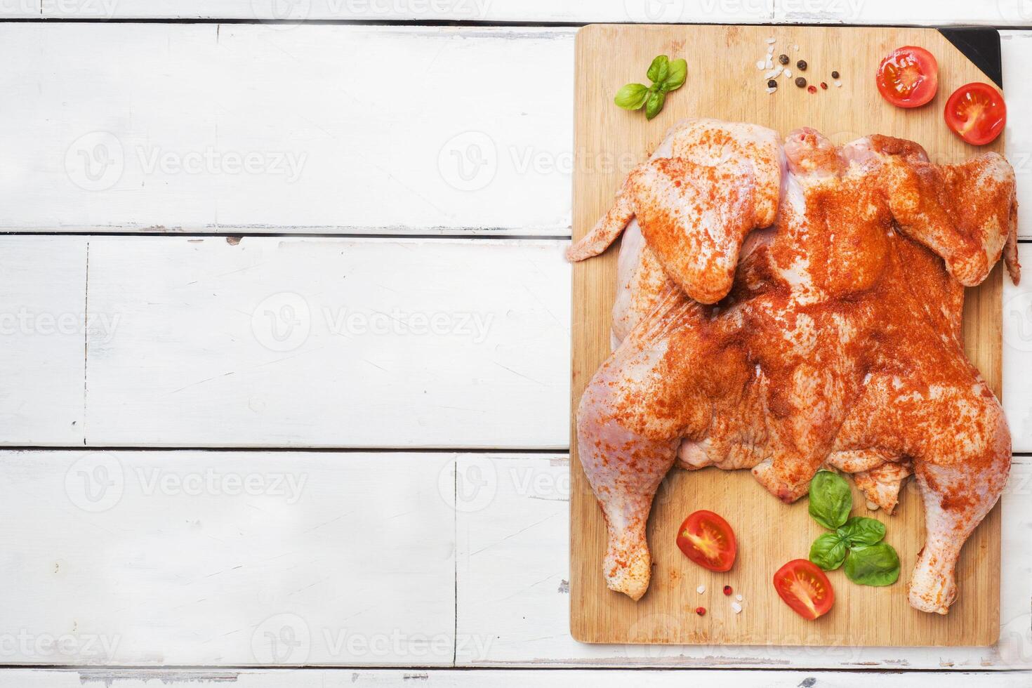 Raw chicken tobacco on a wooden Board with spices and vegetables Copy space photo