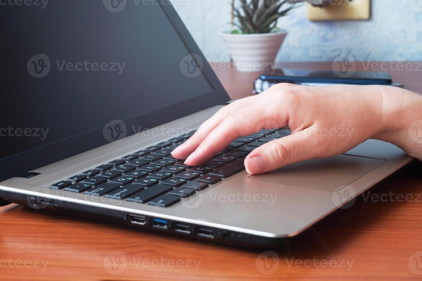 Working wooden table at home or in the office. Woman working at computer hands photo