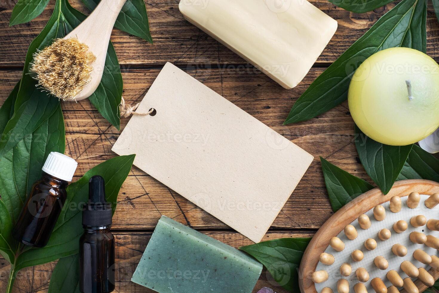 Concept SPA and Wellness. Massage brush, cosmetic oils and soap. Wooden background with green leaf. Copy space photo