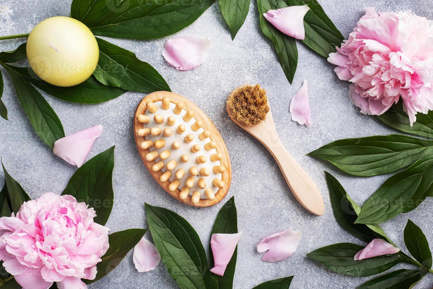 Concept SPA and Wellness. Massage brush, cosmetic oils and soap. Light background with peony flowers. photo
