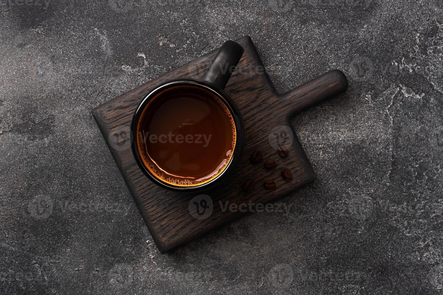 Black coffee in a Cup and coffee beans on a dark background. Top view Copy space. photo