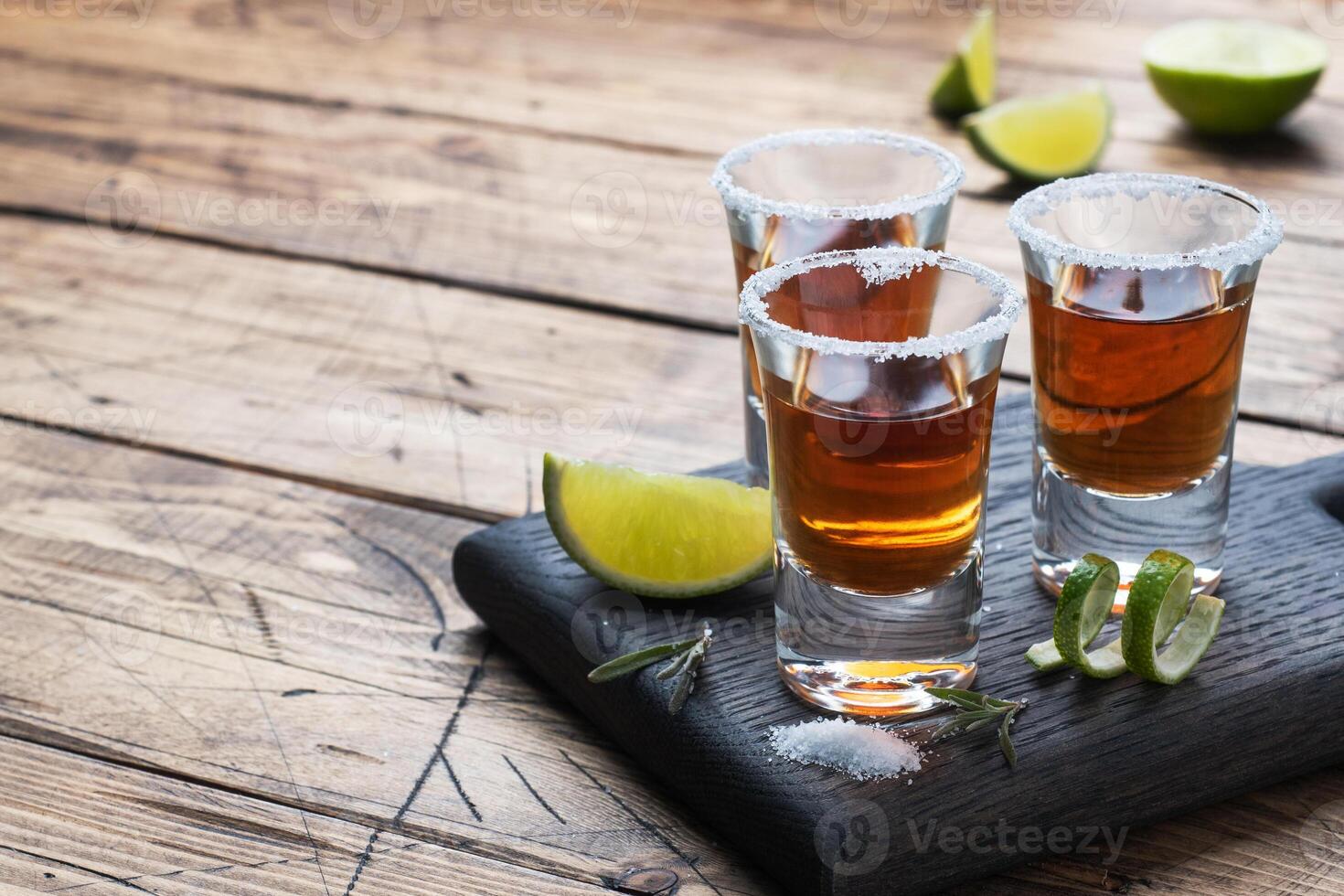 Glass with alcohol, salt and lime on a wooden background. Cognac whiskey tequila. The concept of the party. Selective focus Copy space. photo