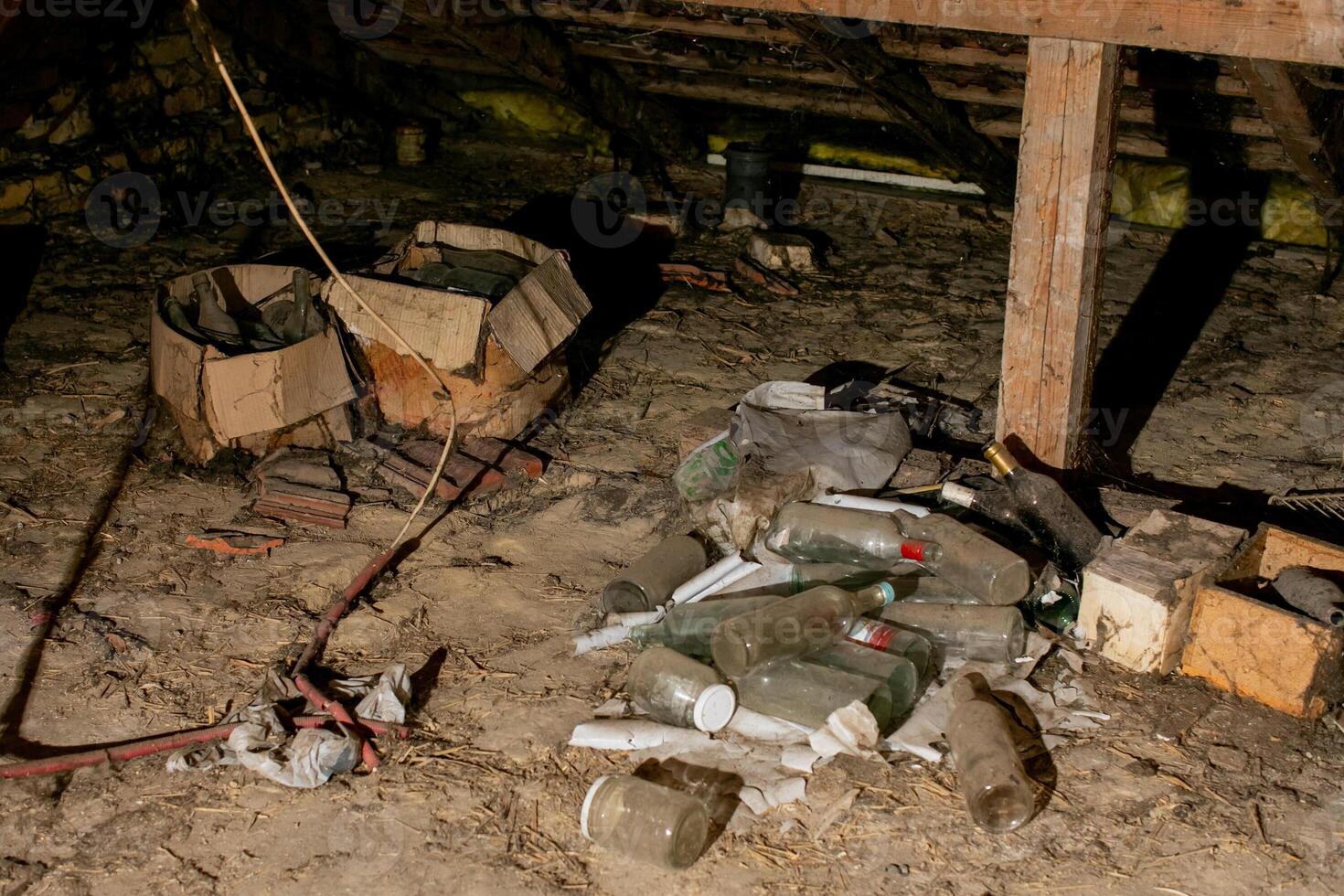 A cluttered, dusty attic full of empty bottles and old boxes, illustrating the need for spring cleaning and organization photo