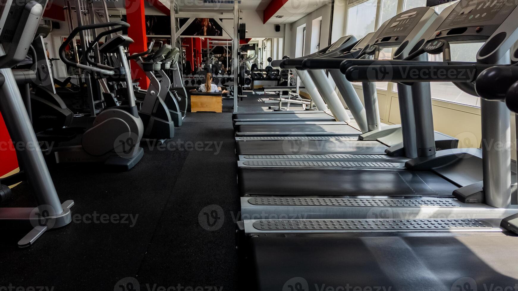Empty modern gym with rows of treadmills and exercise machines, emphasizing wellness and fitness goals photo