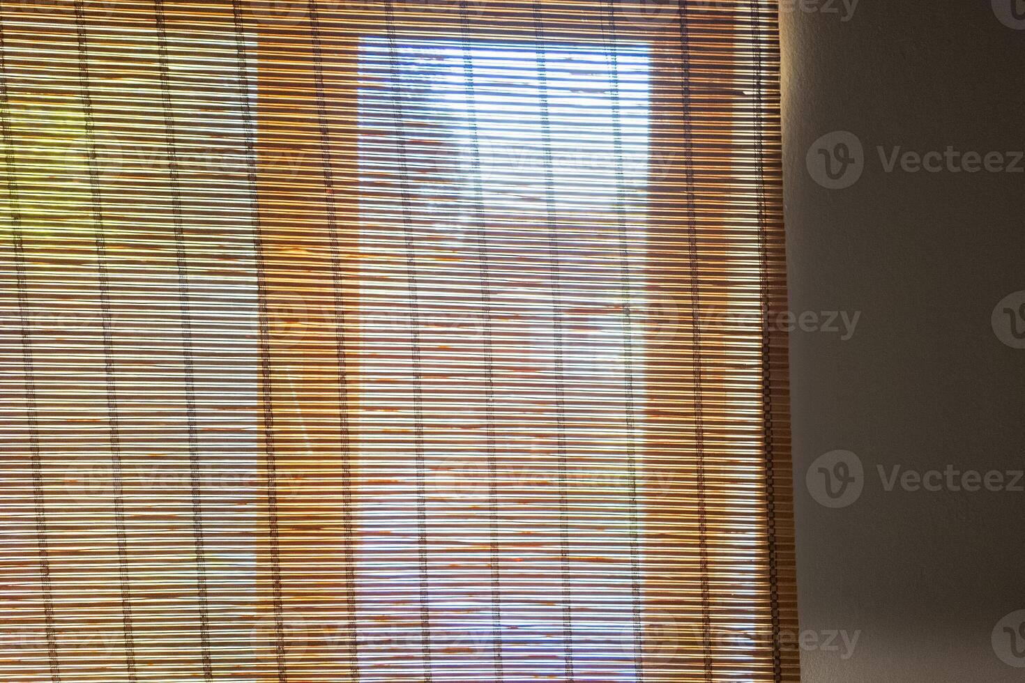 Sunlight filtering through bamboo blinds in a cozy room, representing tranquility and home comfort photo