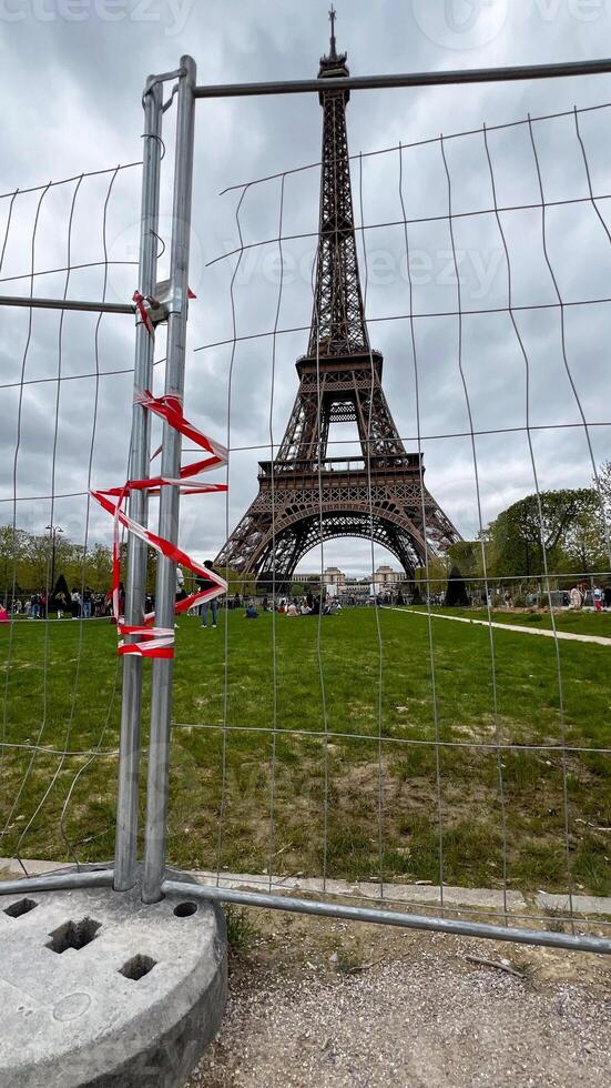 The Eiffel Tower viewed through a construction fence highlights urban development challenges and tourism in Paris photo
