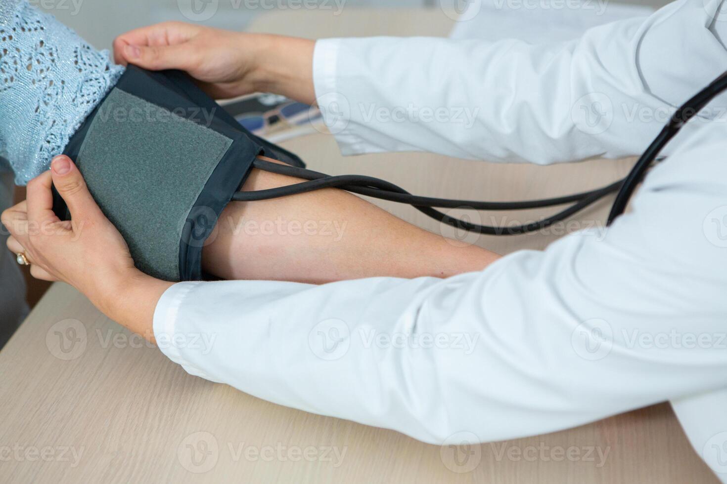 Doctor measuring blood pressure of patient in hospital. Medical and healthcare concept. photo