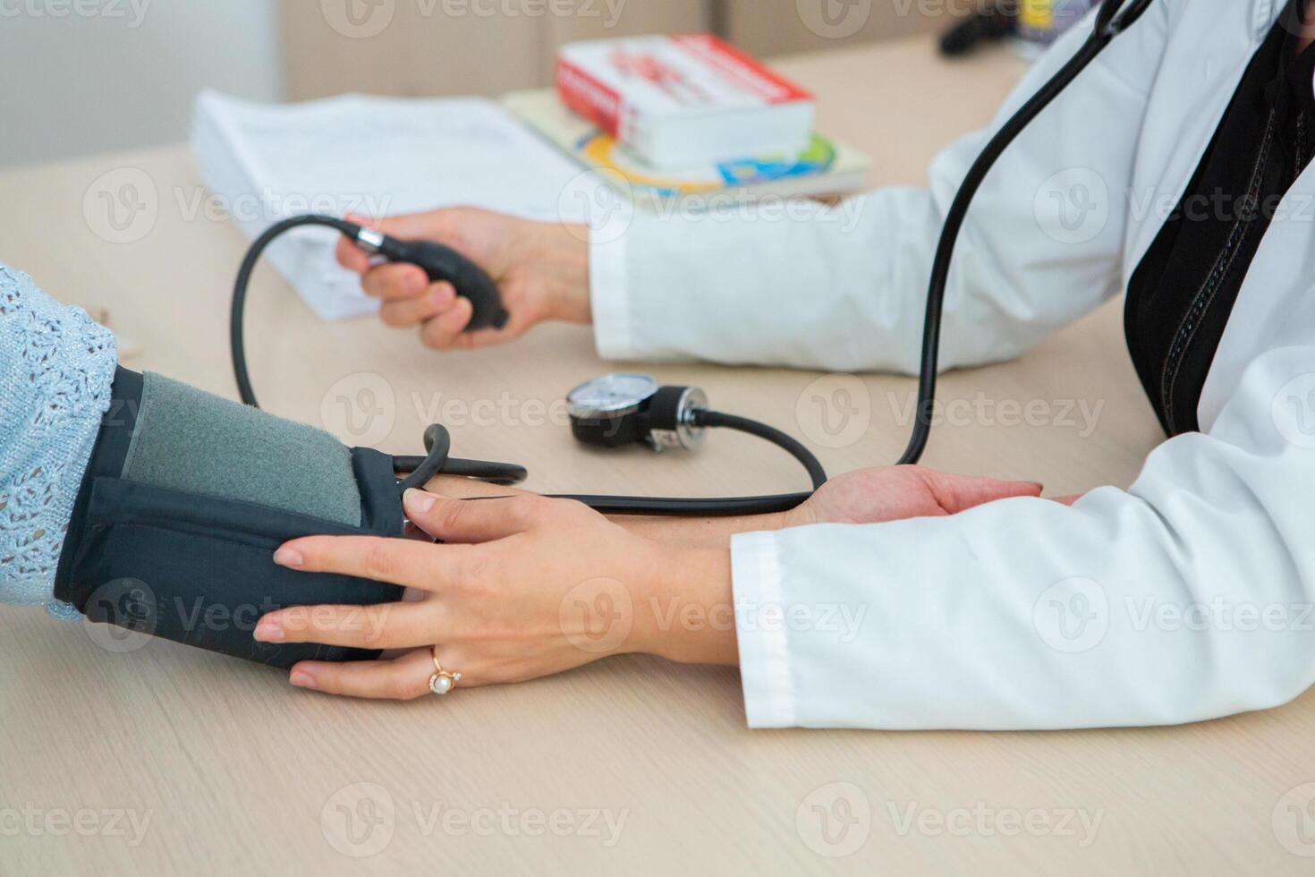 Doctor measuring blood pressure of patient in hospital. Medical and healthcare concept. photo