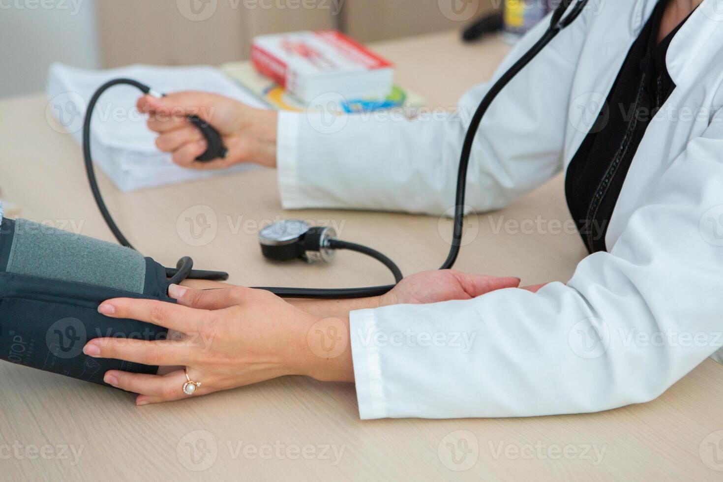 Doctor measuring blood pressure of patient in hospital. Medical and healthcare concept. photo