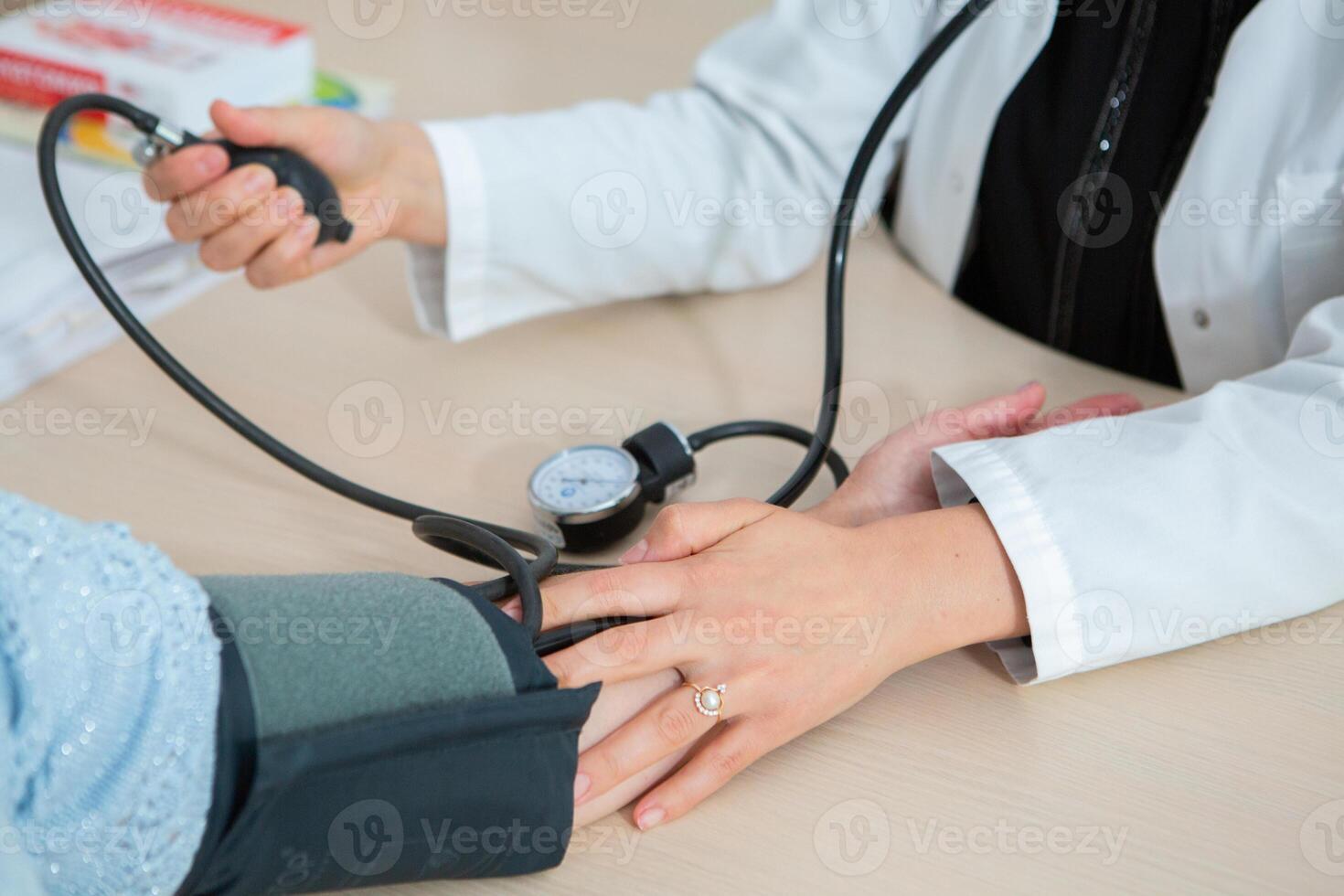 Doctor measuring blood pressure of patient in hospital. Medical and healthcare concept. photo