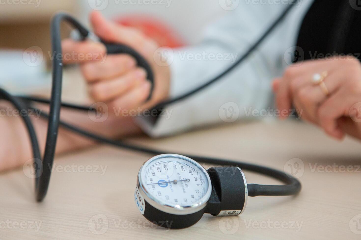 Doctor measuring blood pressure of patient in hospital. Medical and healthcare concept. photo