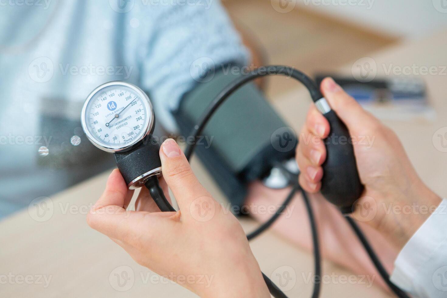 Doctor measuring blood pressure of patient in hospital. Medical and healthcare concept. photo