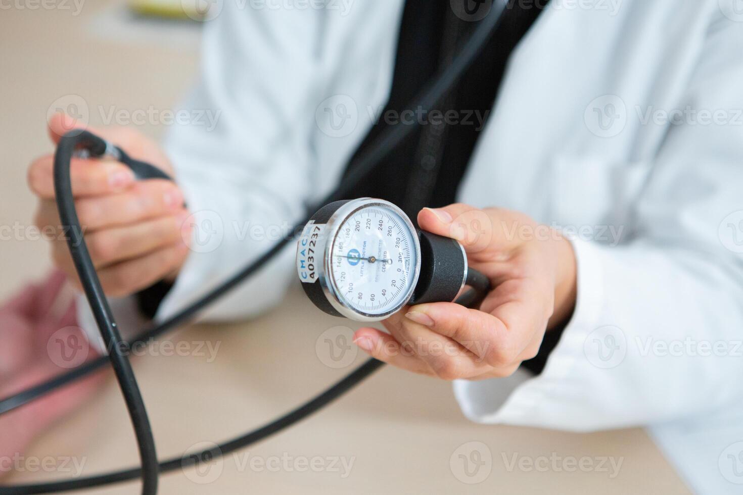 Doctor measuring blood pressure of patient in hospital. Medical and healthcare concept. photo