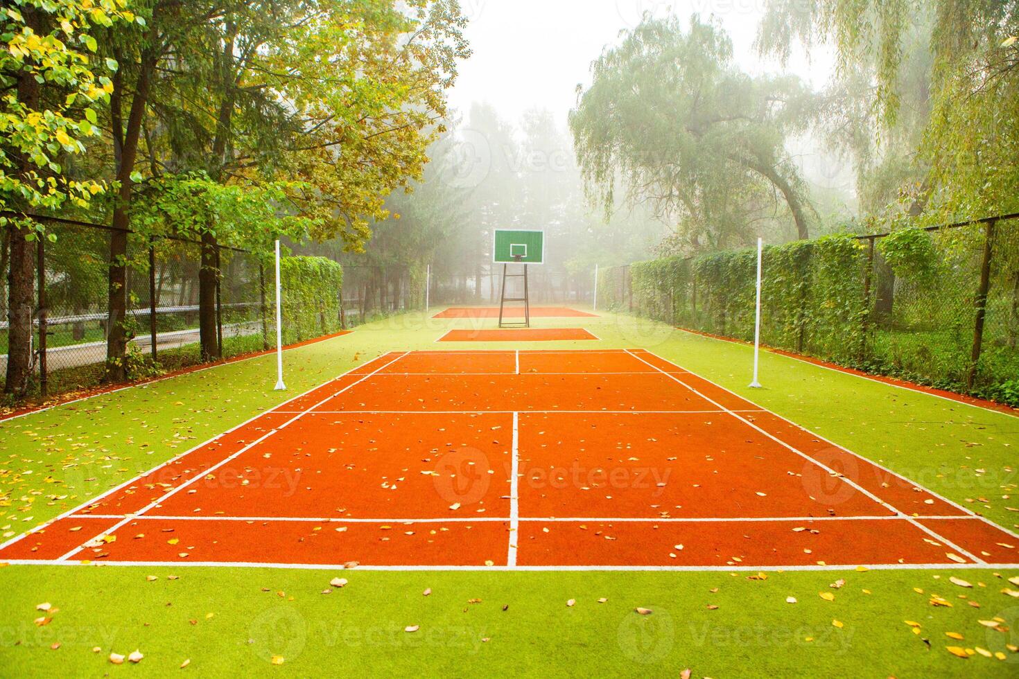 Empty tennis court in foggy morning at public park. sport background concept. photo