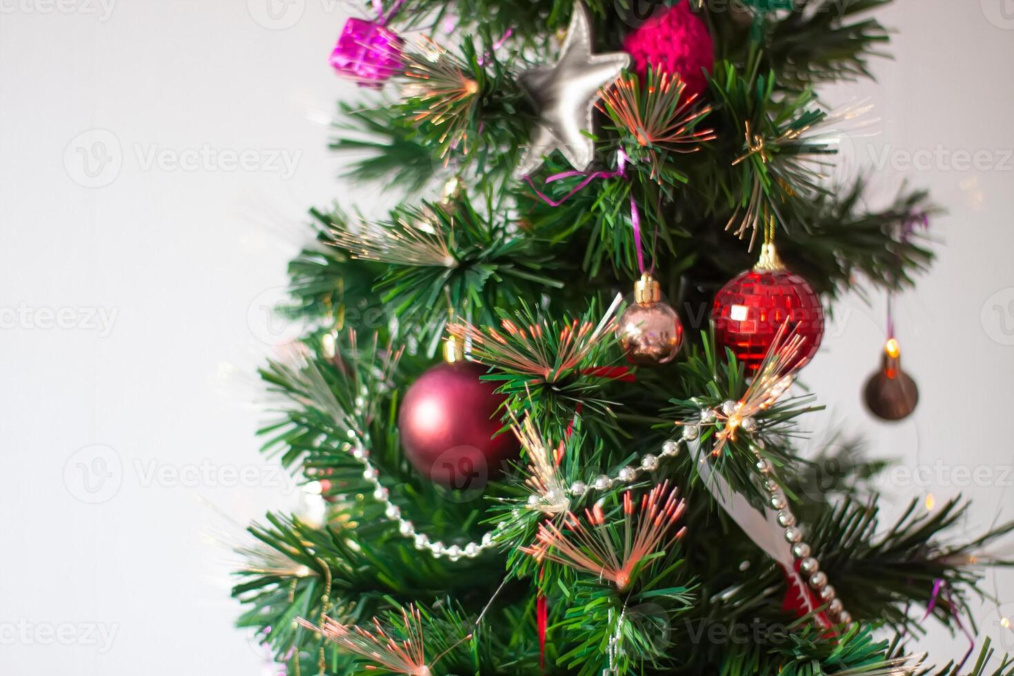 Artificial Christmas tree in a home interior decorated with bauble, balls and toys. photo