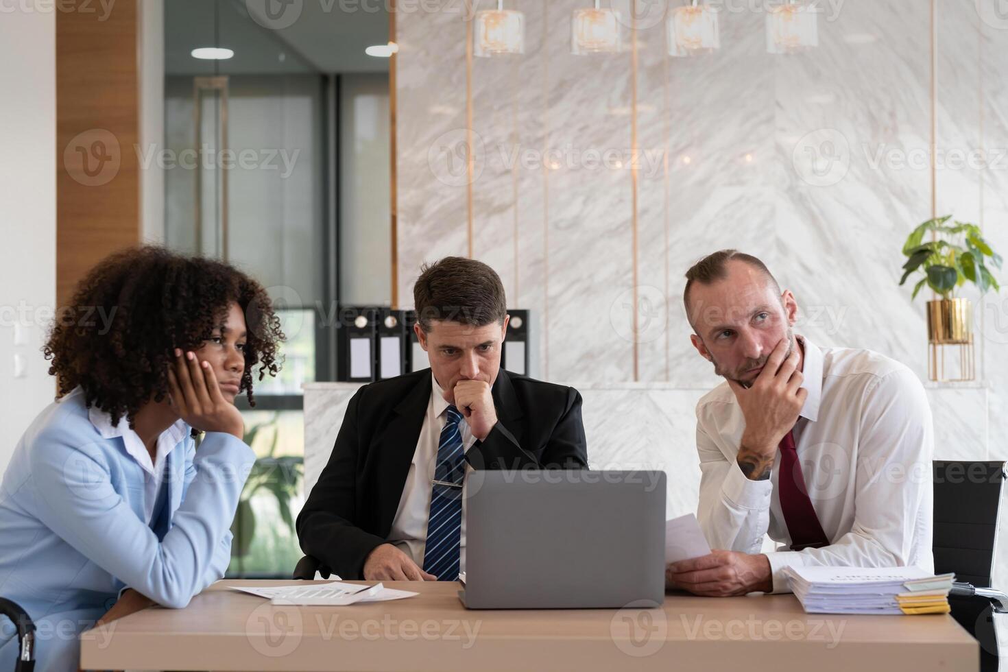 Diverse business team contemplating at office desk, Concept of strategic decision-making photo