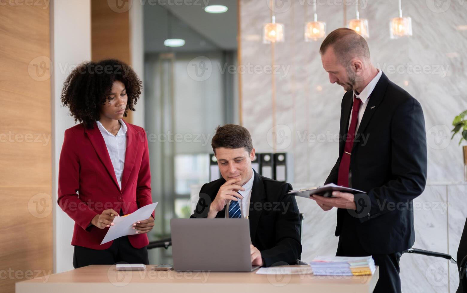 Diverse business team reviewing documents at office desk, Concept of teamwork photo