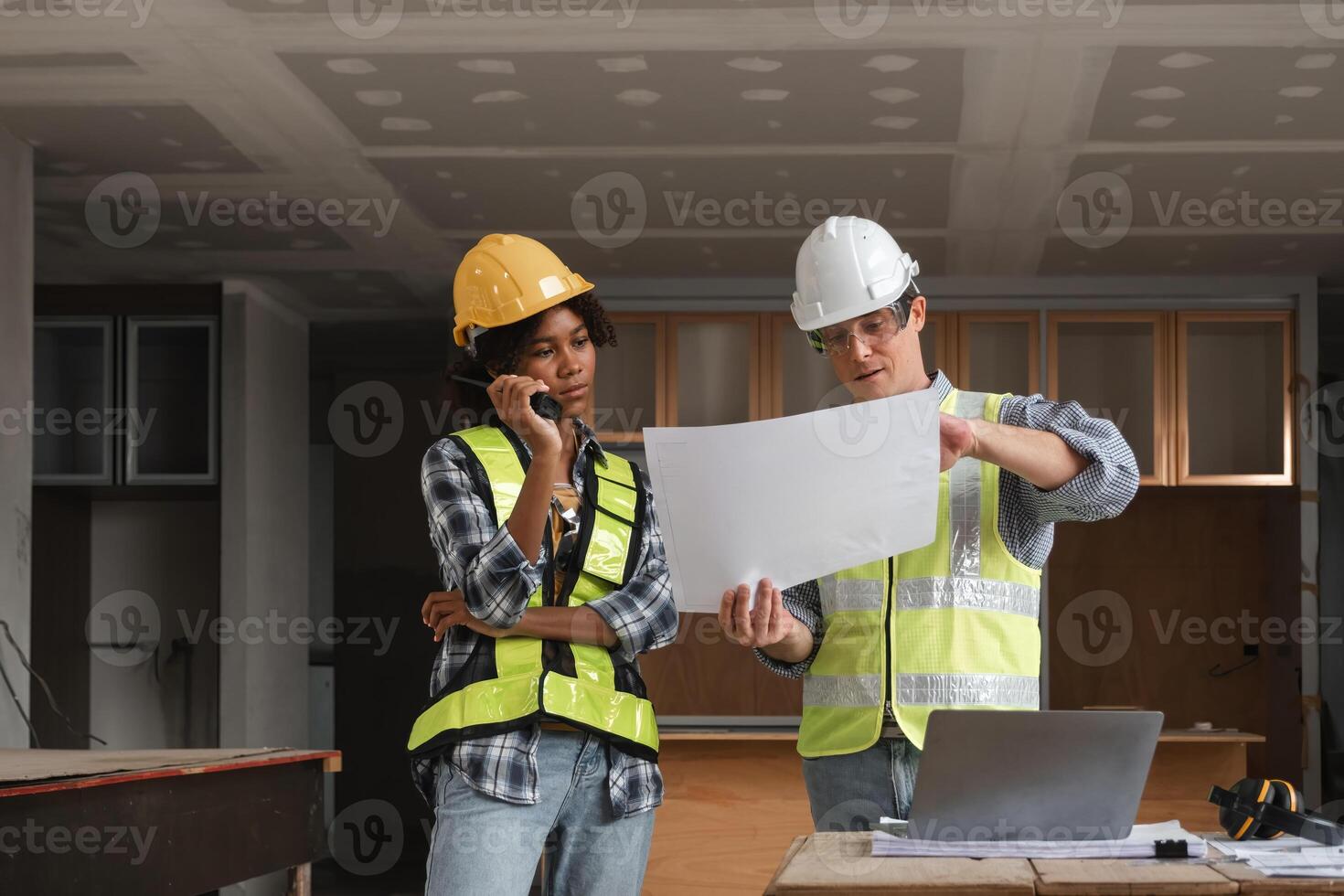 Engineering Team Planning Construction Work with Blueprints and Safety Gear in Modern Building Site photo
