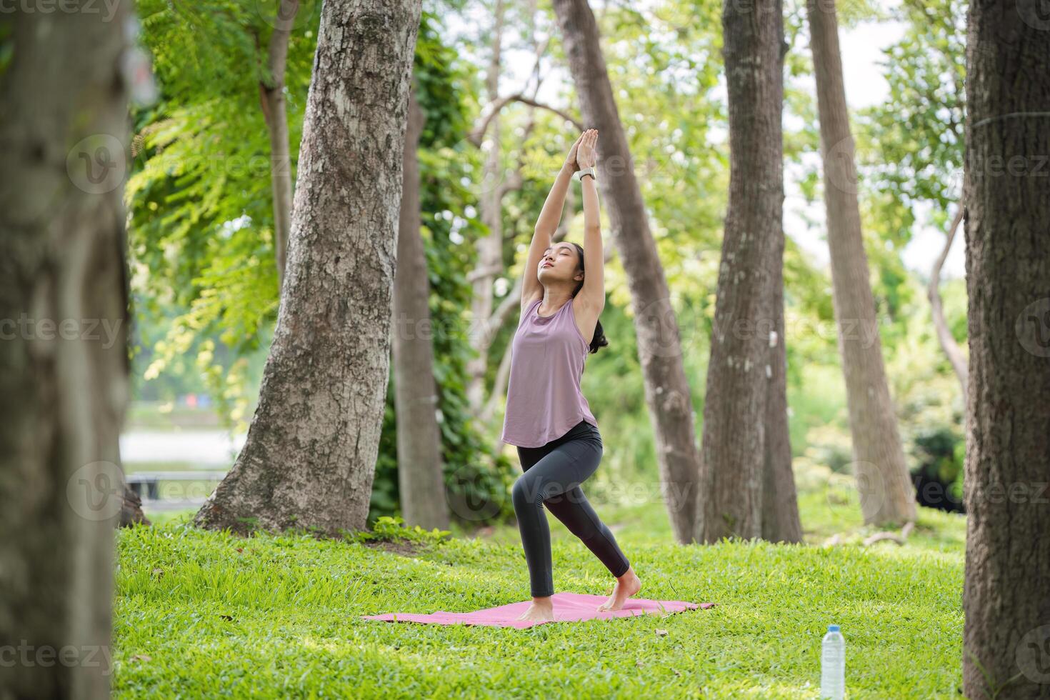 Woman Practicing Yoga in the Park, Relaxing and Meditating Outdoors in a Serene Natural Setting photo