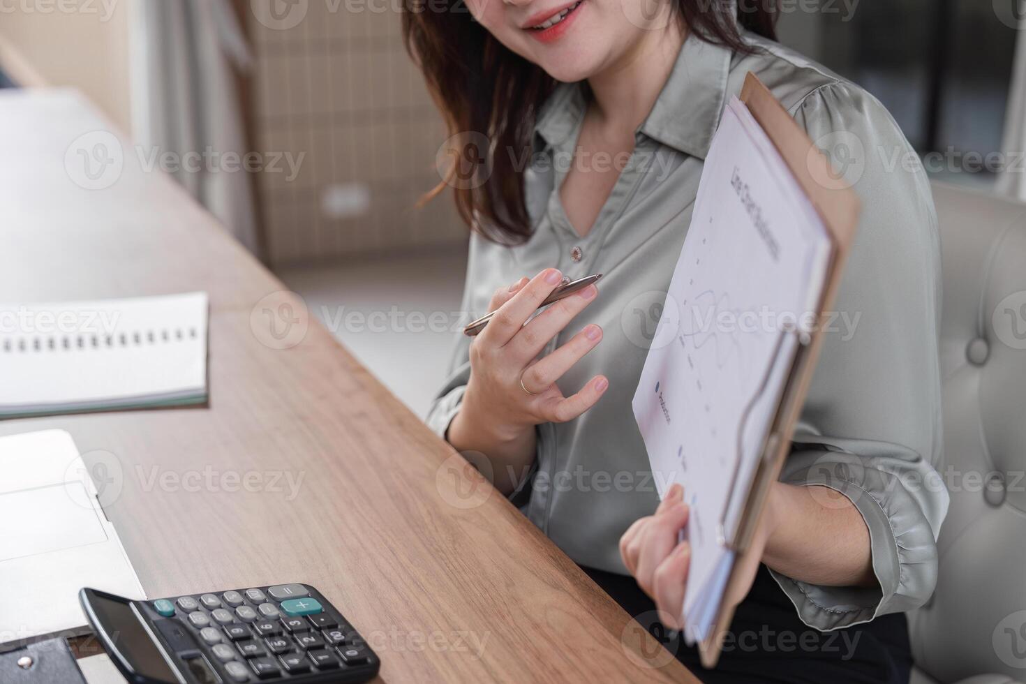 Focused Businesswoman Analyzing Documents and Strategizing Work Plans in a Modern Office Setting photo