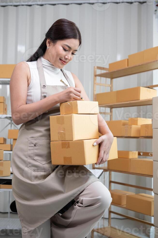 Woman Packing Boxes of Merchandise for Online Sales in a Modern Warehouse Setting photo