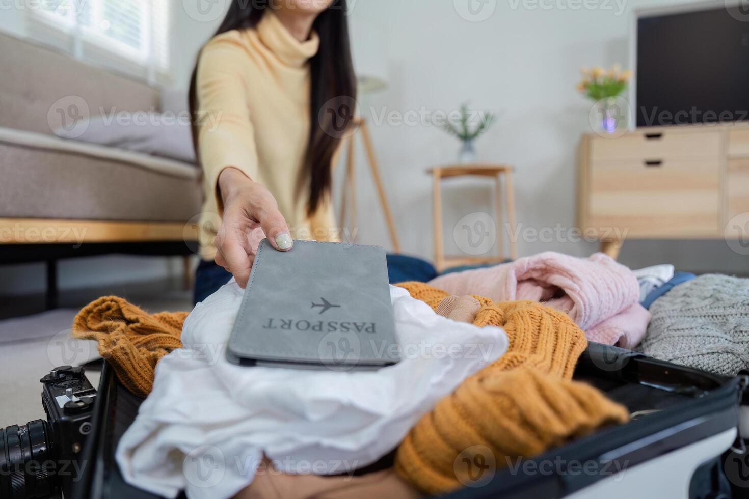 Young Woman Preparing Passport and Packing Suitcase for Exciting Tourist Trip photo