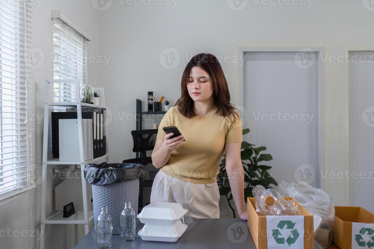 Young Woman Sorting Plastic Bottles and Containers for Recycling at Home in a Modern, Eco-Friendly Environment photo