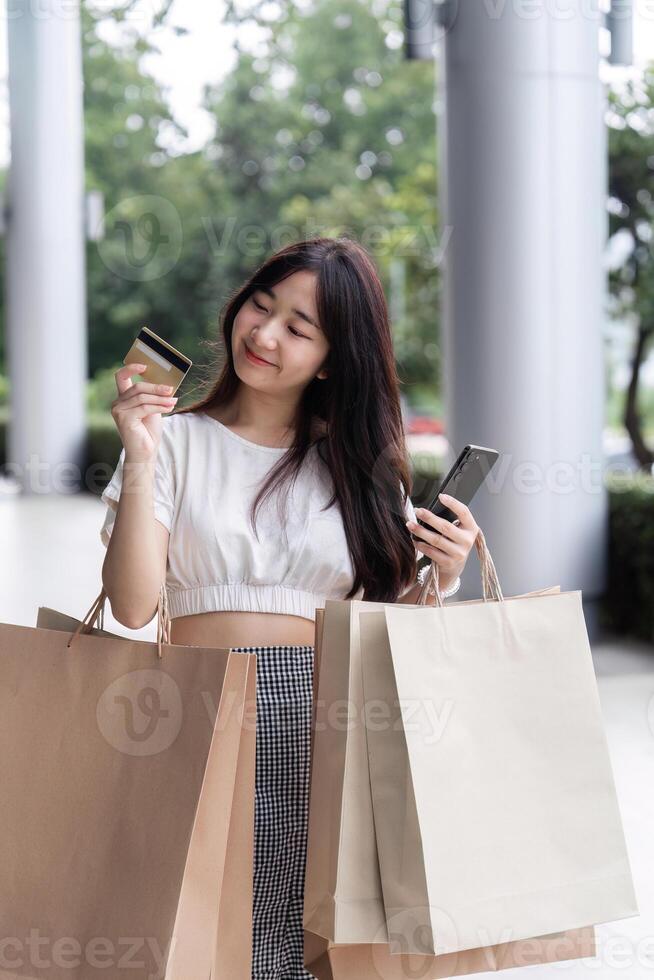 Happy Woman Shopping at the Mall with Paper Bags and Credit Card in Hand, Enjoying a Day of Retail Therapy and Modern Fashion photo